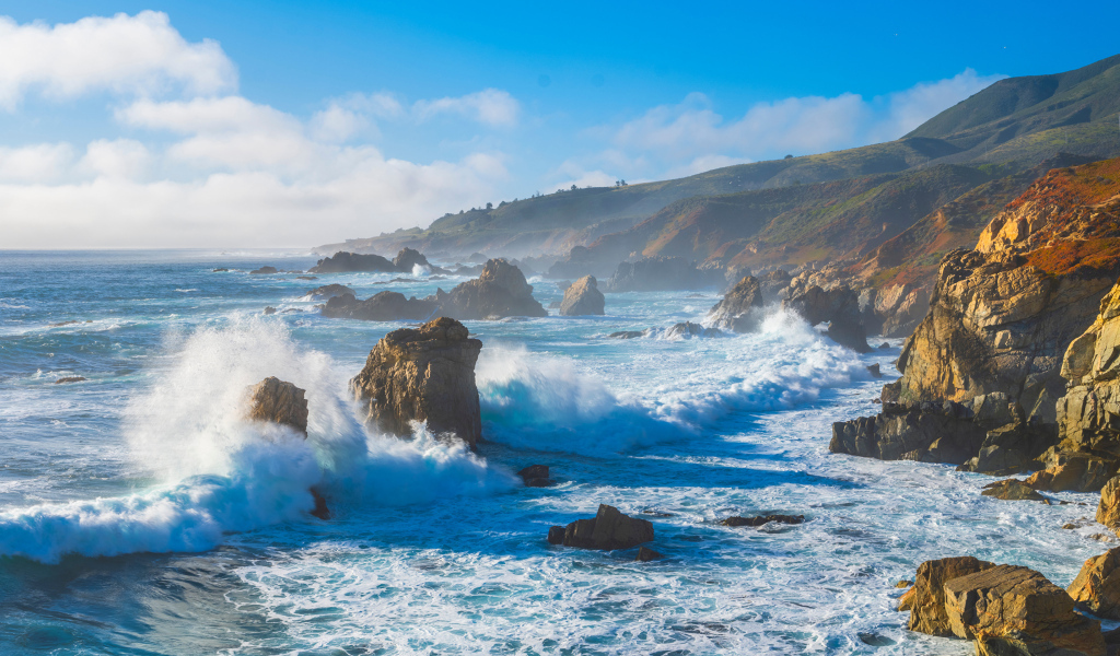 Белые бушующие волны бьются о камни 