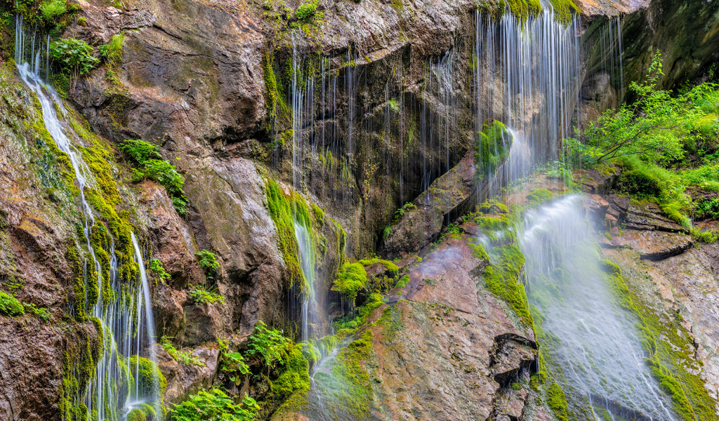 Водопад стекает по большим холодным камнях