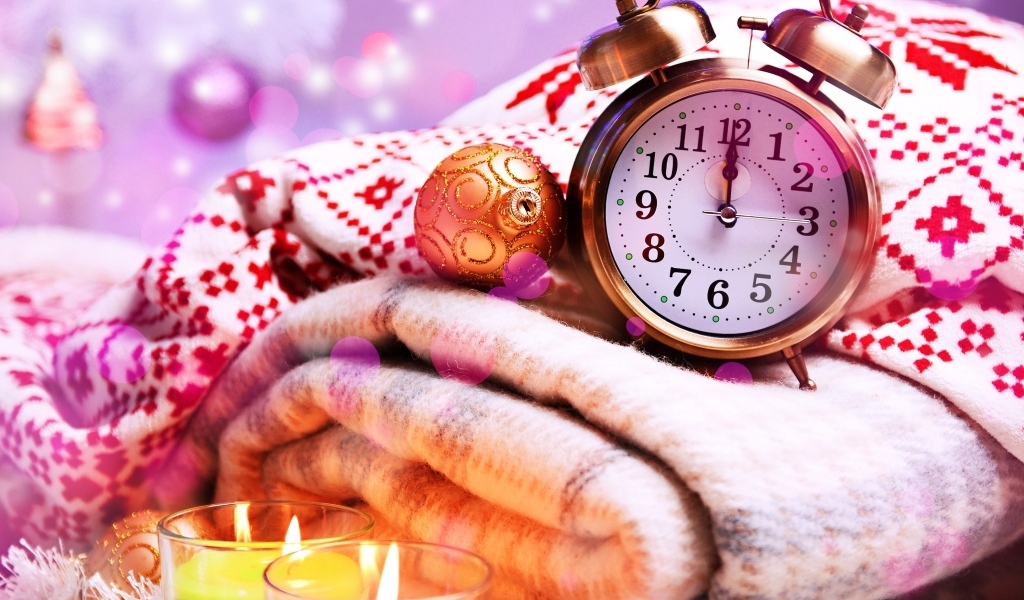 Будильник, теплый плед и зажженные свечи на праздник