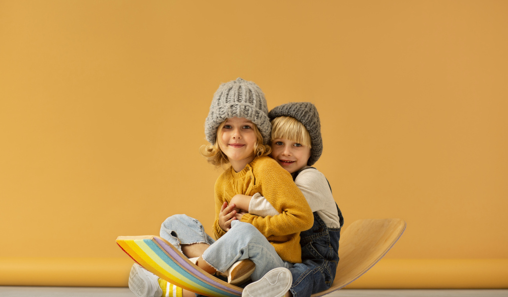 Счастливые брат и сестра в теплых шапках
