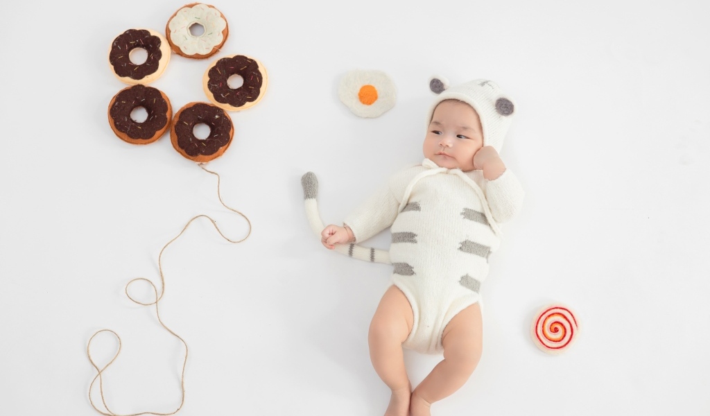 Маленький ребенок с игрушками в форме пончика