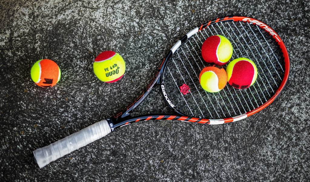 Ракетка и теннисные мячи на черном фоне