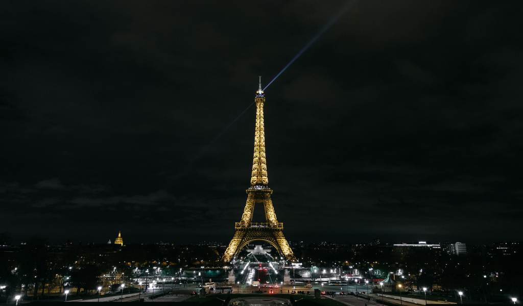 Высокая Эйфелева башня светит огнями ночью, Франция