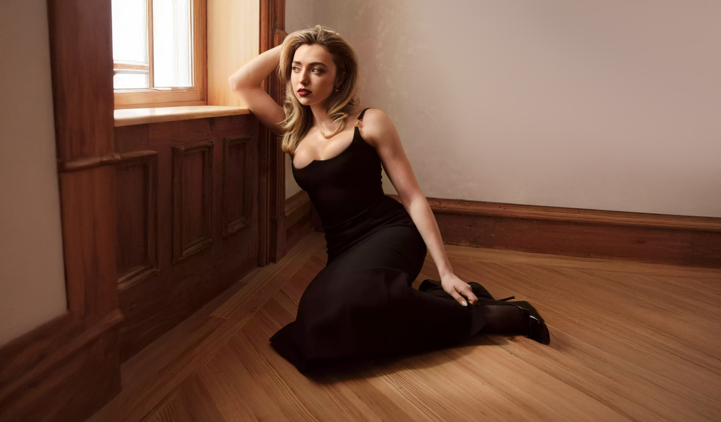 Актриса Пейтон Рой Лист в черном платье сидит на полу у окна