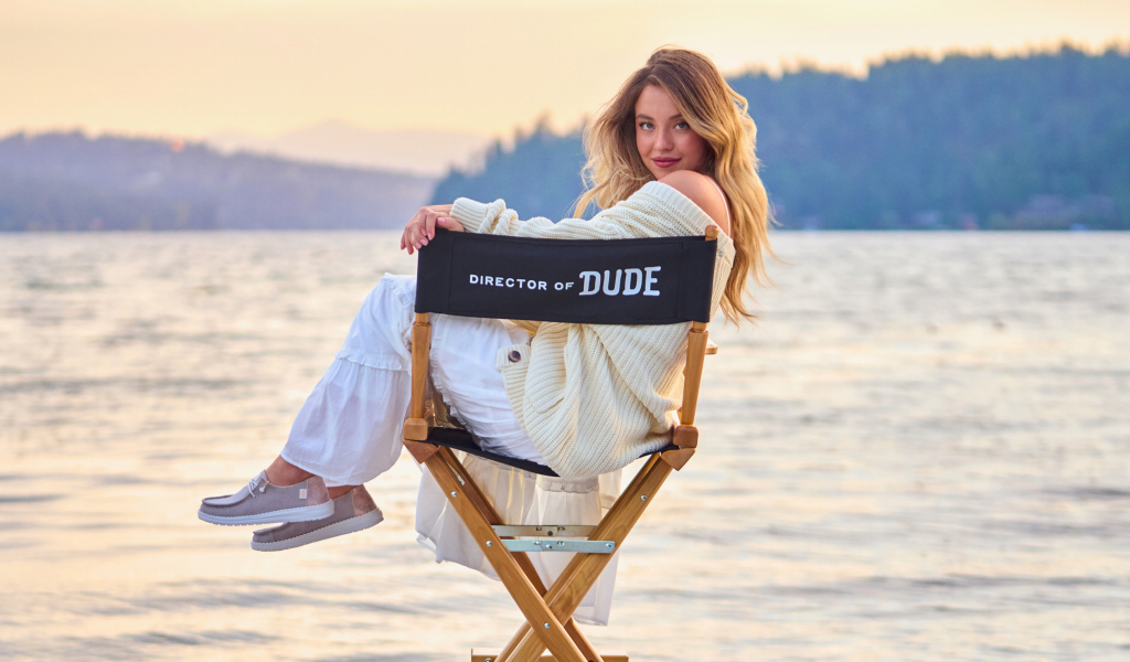 Актриса Сидни Суини сидит на стуле у озера