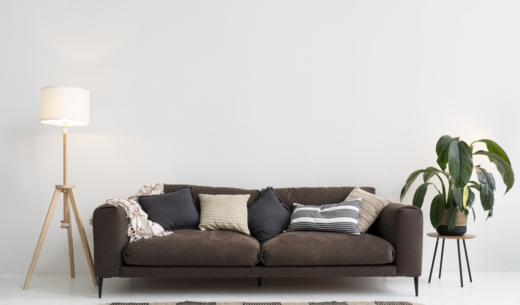 Коричневый диван у серой стены с лампой