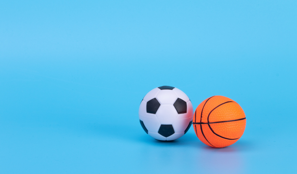 Футбольный и баскетбольный мяч на голубом фоне