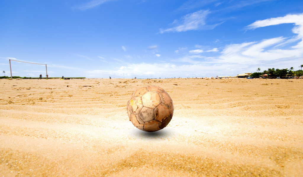 Старый футбольный мяч на песке