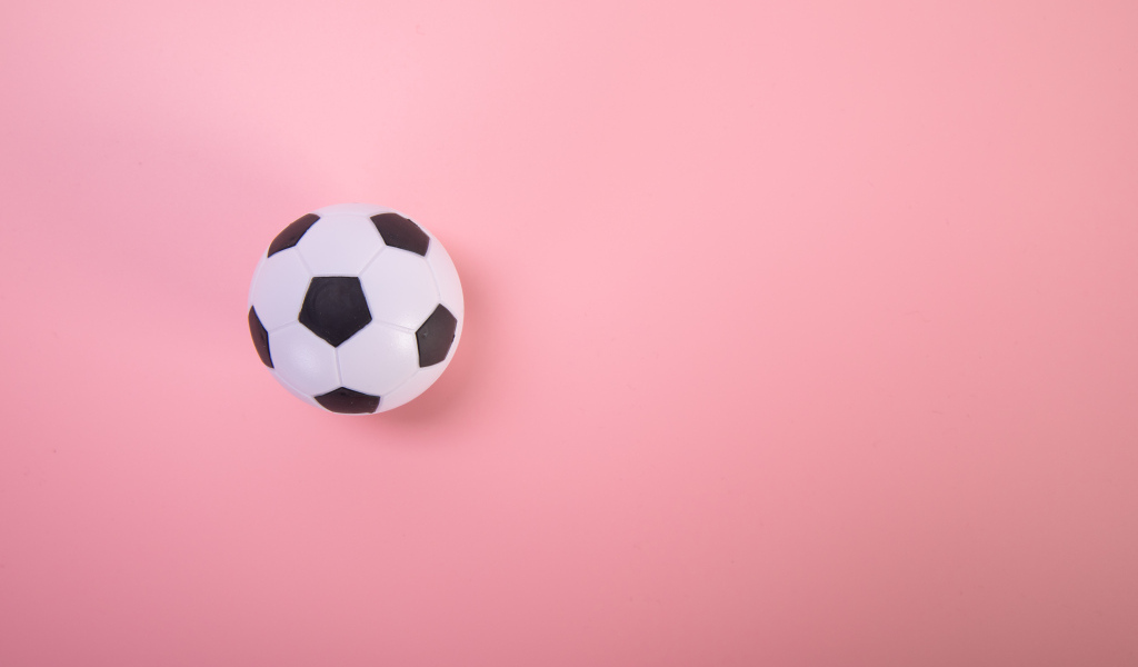 Футбольный мяч на розовом фоне