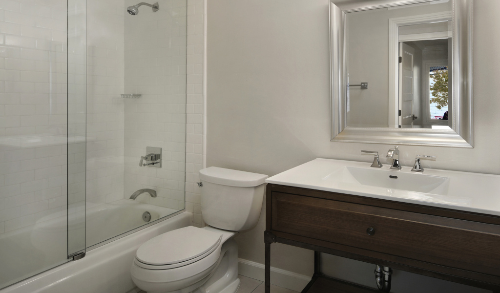 Интерьер ванной комнаты в белом цвете с душевой кабиной и унитазом