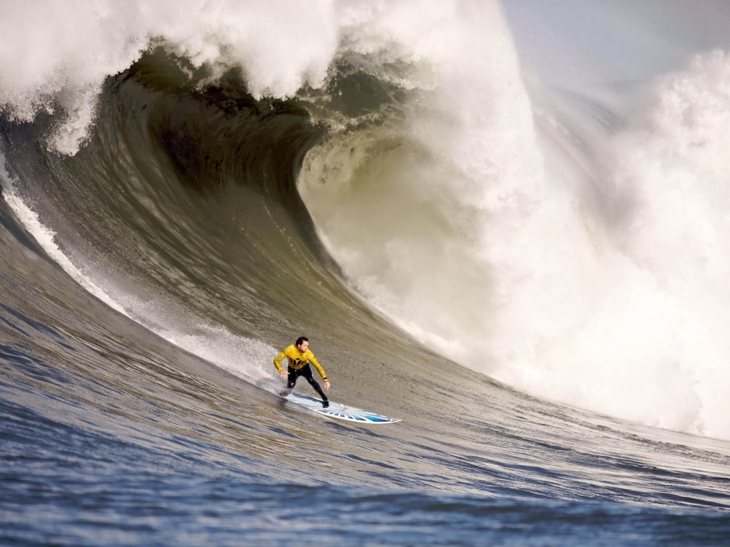 Серфер спускается с волны