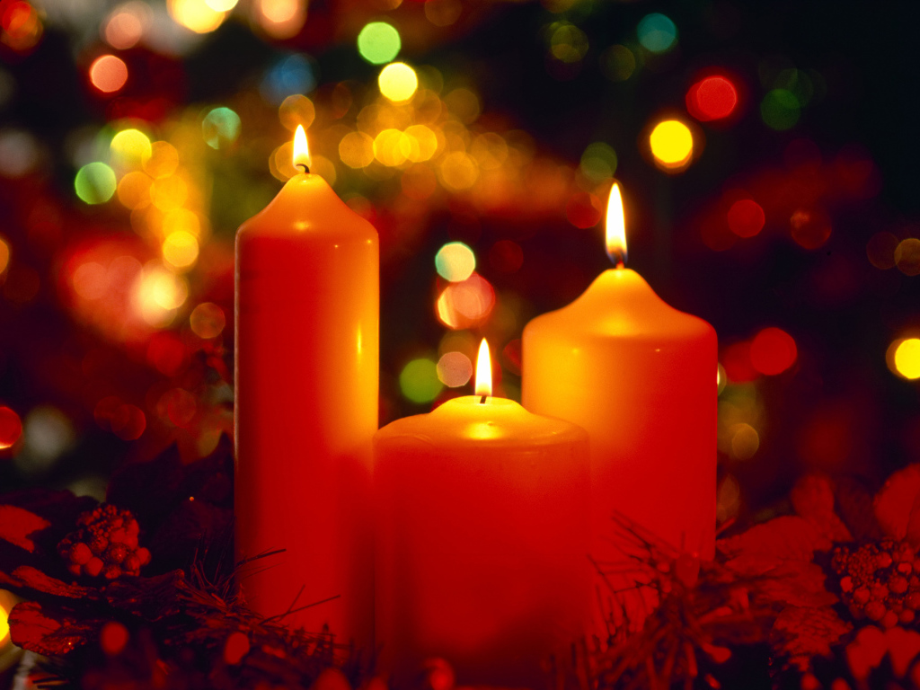 Горящие красные свечи на фоне гирлянды на рождество