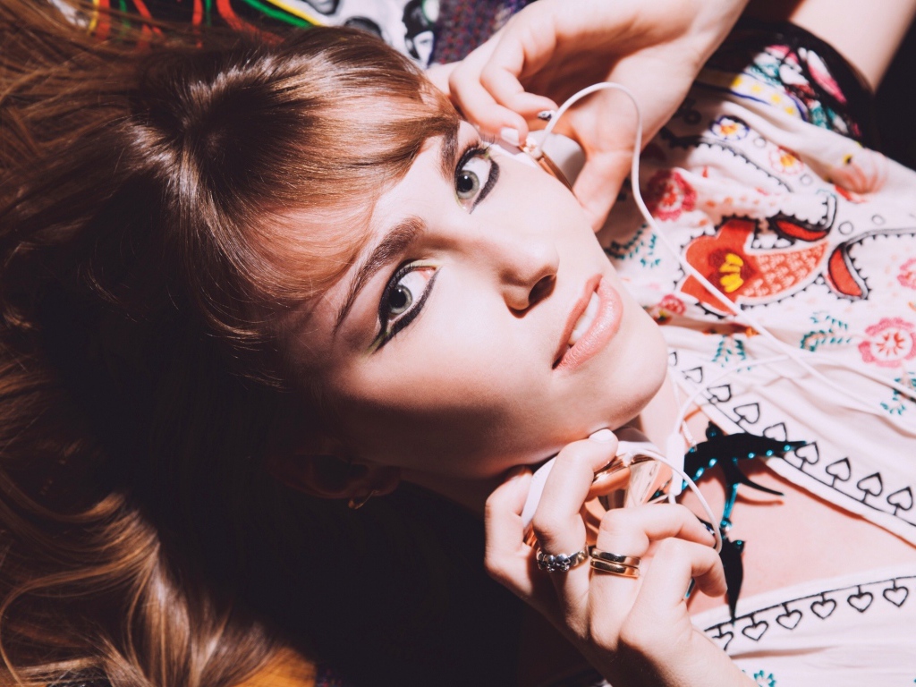 Девушка лежит с наушниками