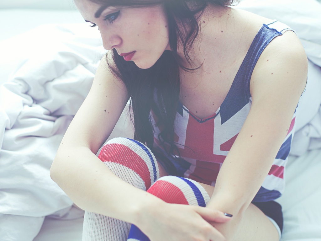 Девушка грустит на кровати