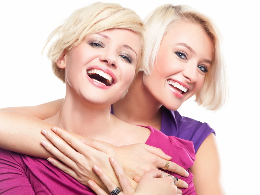 Две белозубые девушки смеются