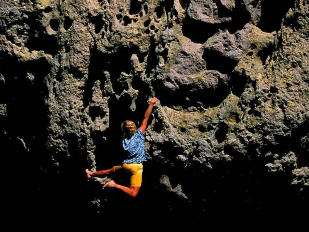 Девушка занимается скалолазаньем