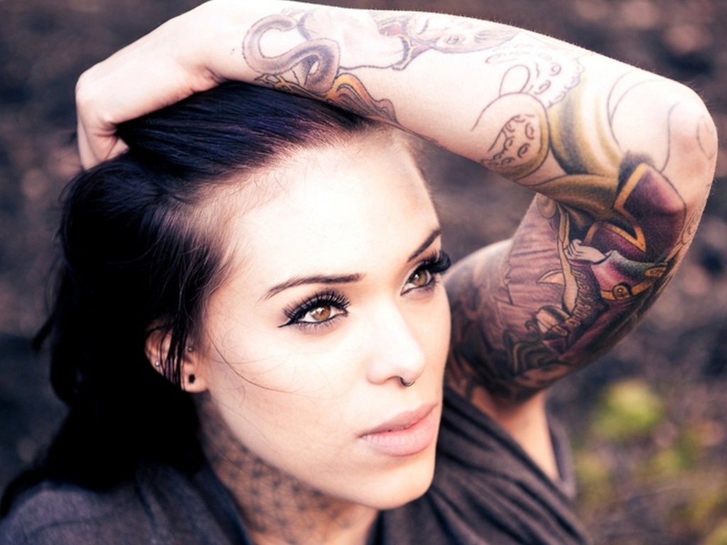 Девушка с цветной татуировкой на руке