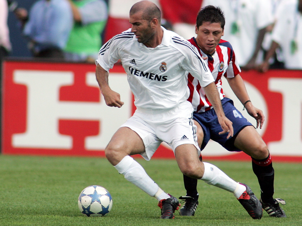 Легенда футбола Зинедин Зидан передавая мяч