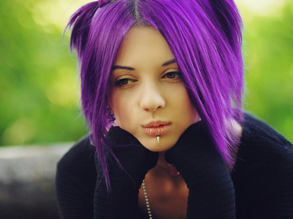 Молодая девушка с пирсингом в носу и губах