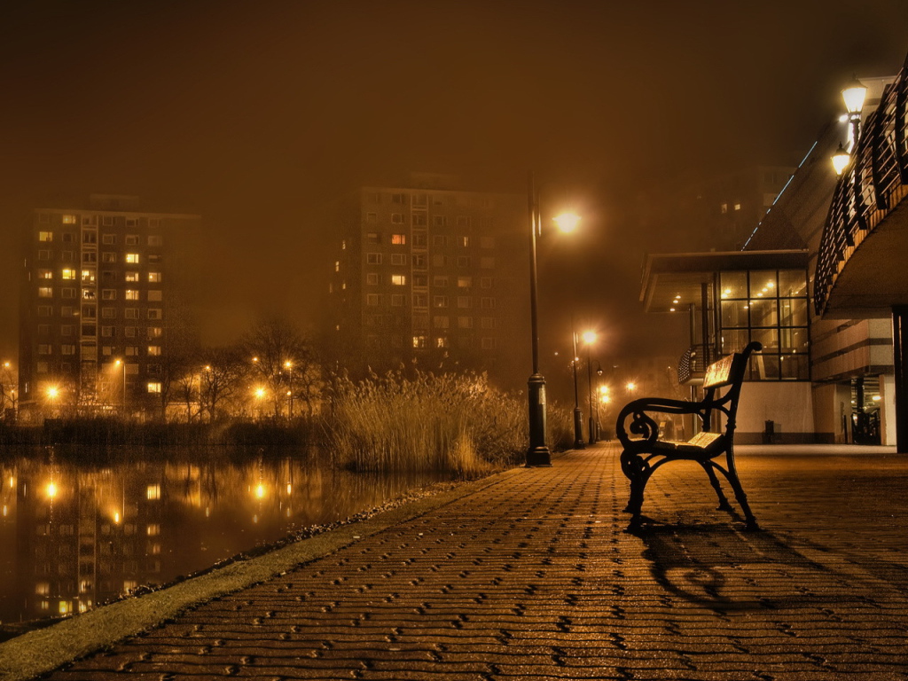 Скамейка около реки в городе