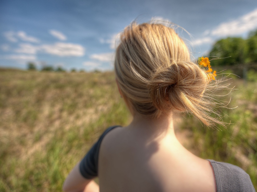 Девушка с цветами в волосах в поле