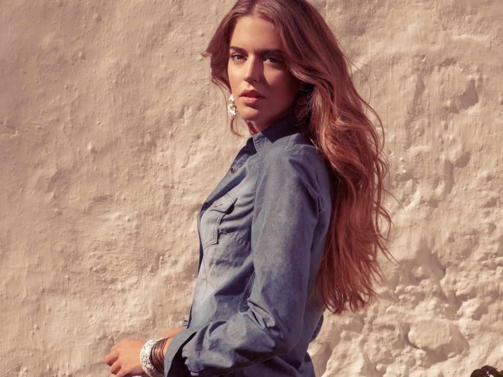 Красивая девушка на фоне песчанной стены