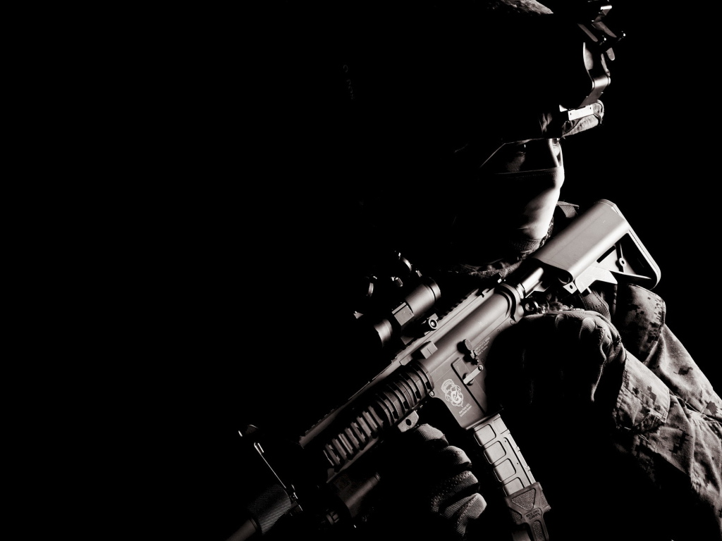 Солдат с оружием на черном фоне
