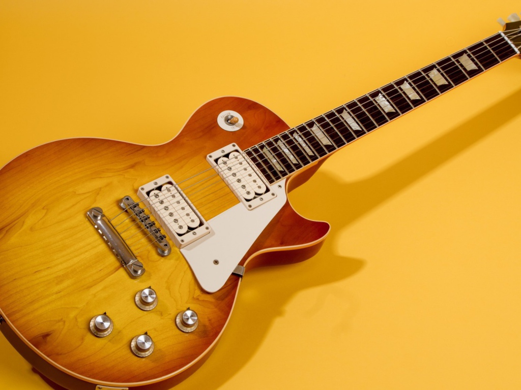 Гитара с тенью на жёлтом фоне