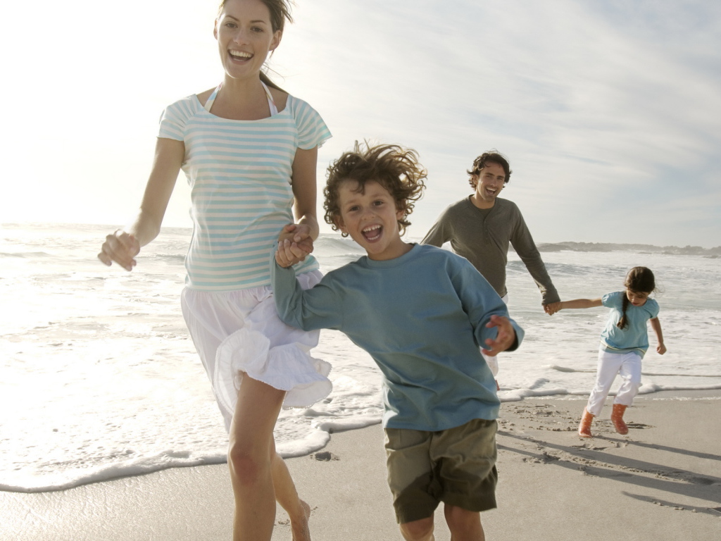 Семья гуляет на пляже