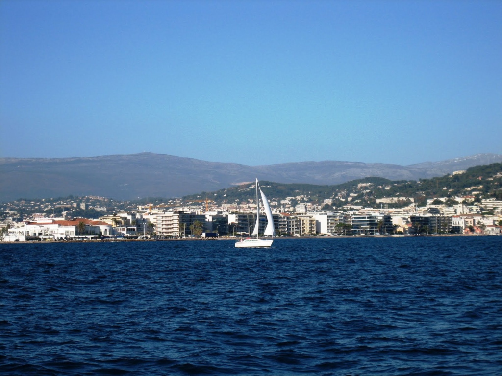 Яхта на фоне города на курорте Порт Де Фрежюс, Франция