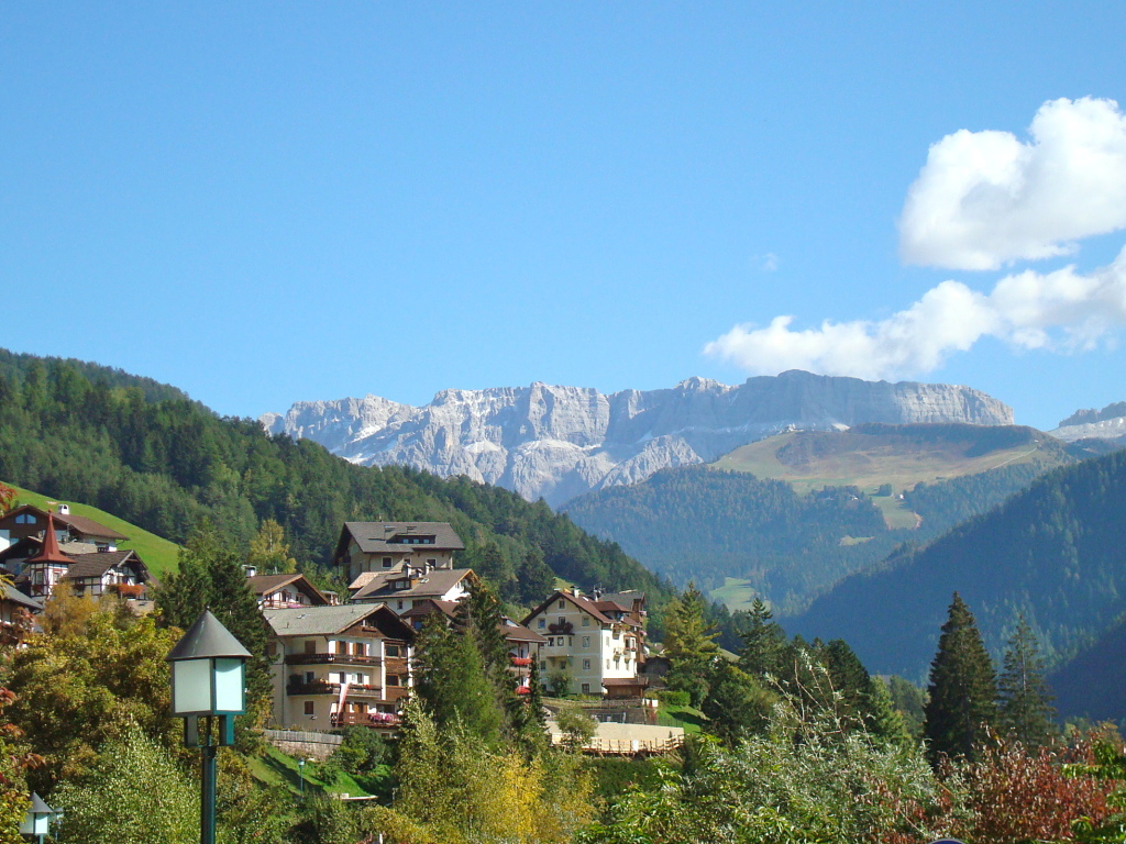 Дома на склоне горы на курорте Ортизей, Италия