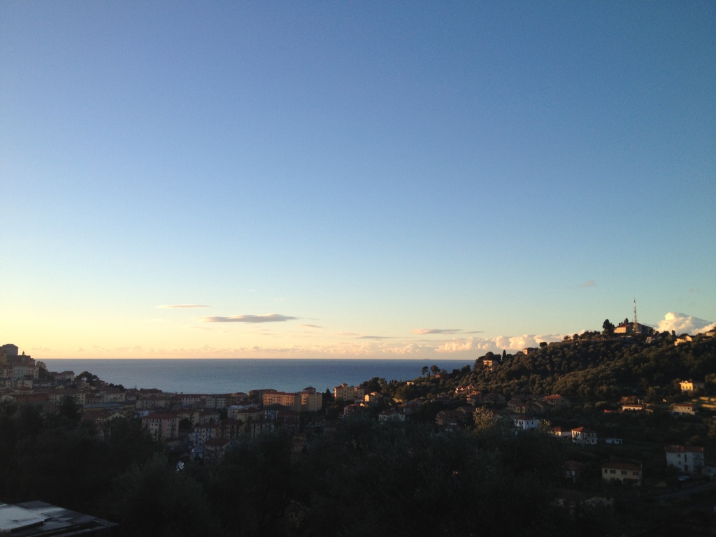 Закат над городом на курорте Империя, Италия