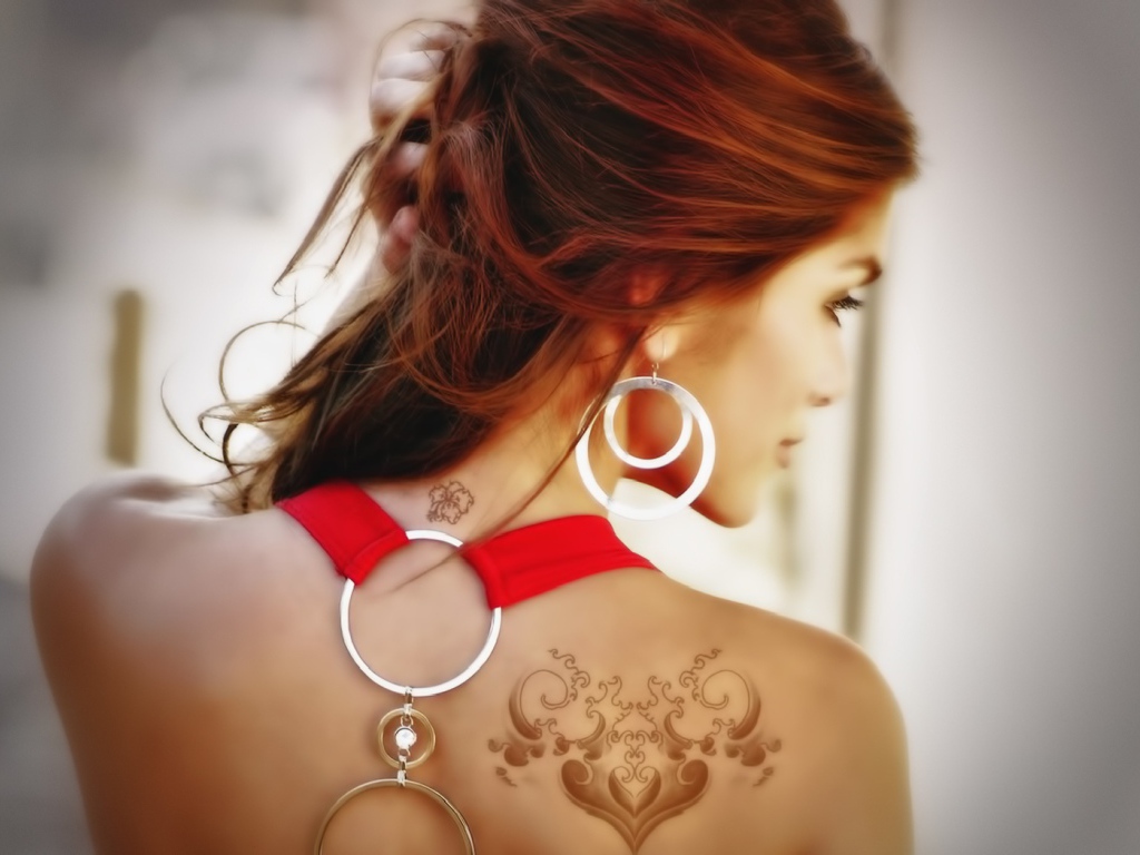 Девушка с татуировками на плече и шее