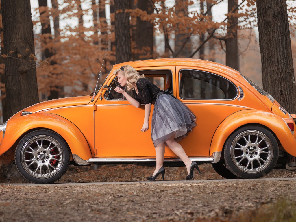 Девушка красит губы у зеркала старого автомобиля