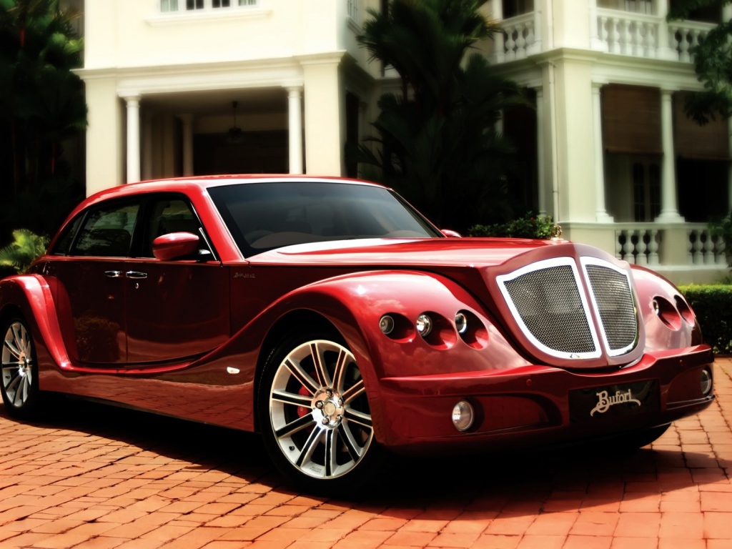 Красный роскошный автомобиль на мощеной дорожке