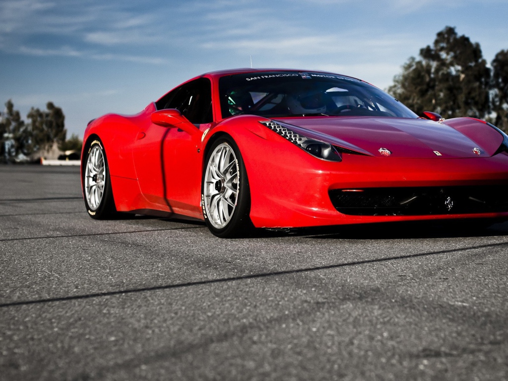 Красный спортивный автомобиль на гладком сером асфальте