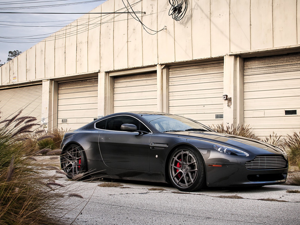 Автомобиль Aston Martin у складского здания