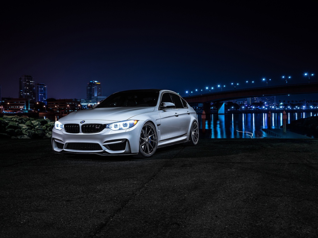 Серебристый BMW на фоне ночных огней