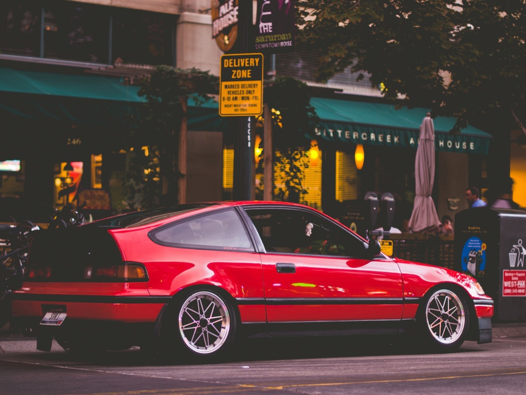 Красная Honda CRX стоит у уличного кафе