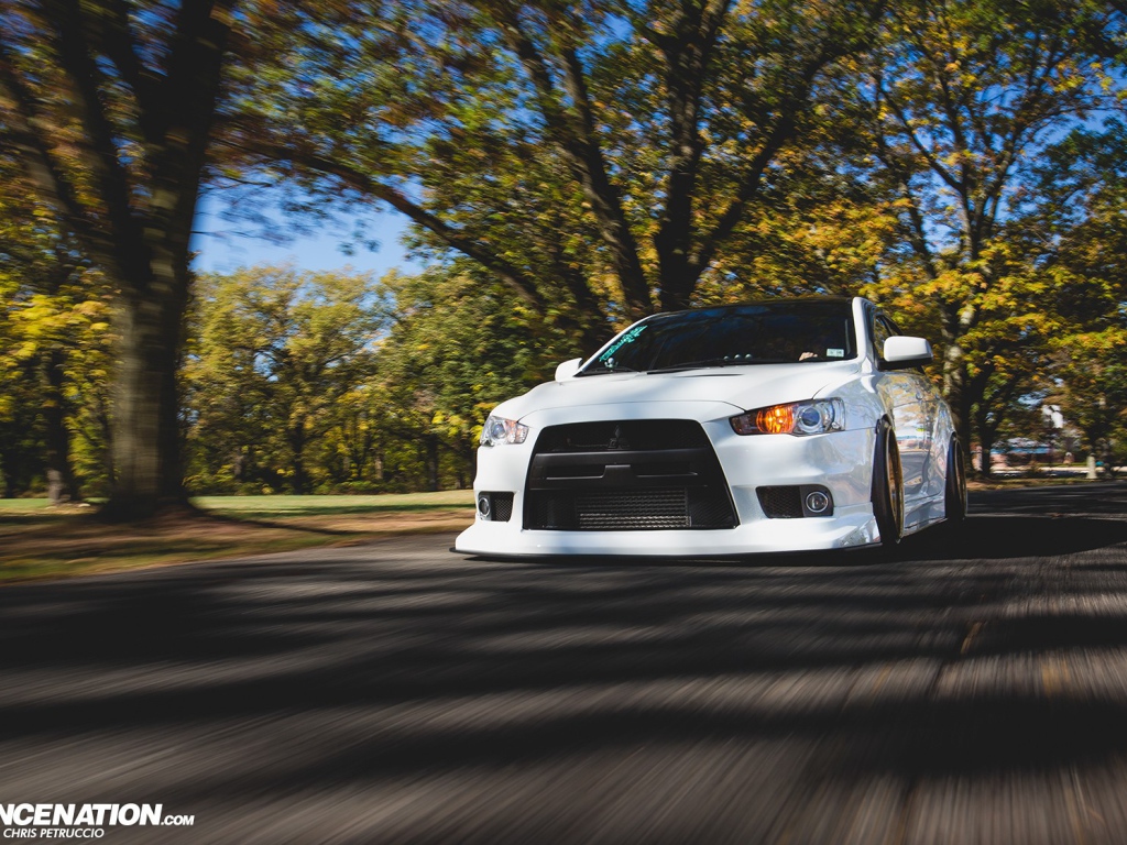 Белый Mitsubishi Lancer Evo X на дороге
