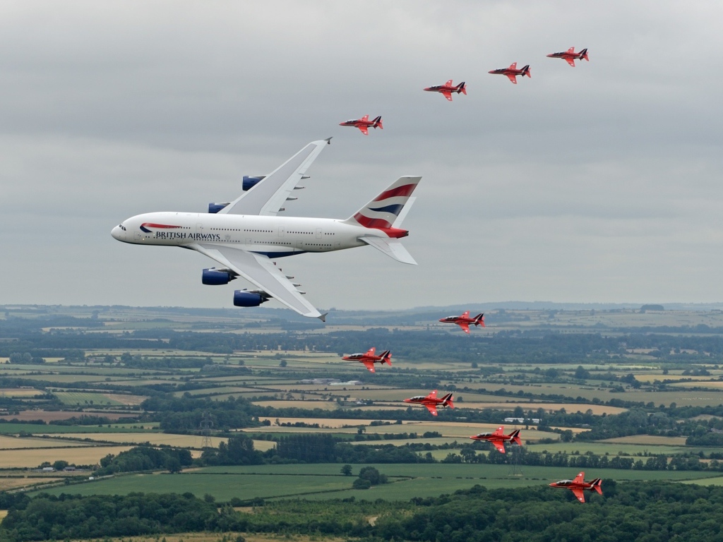 Airbus A380 в сопровождении красных истребителей