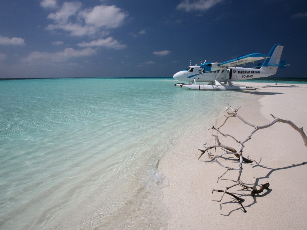 Самолет сел на воду у белого пляжа