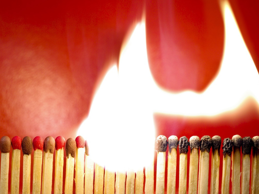 Горящий ряд спичек на красном фоне