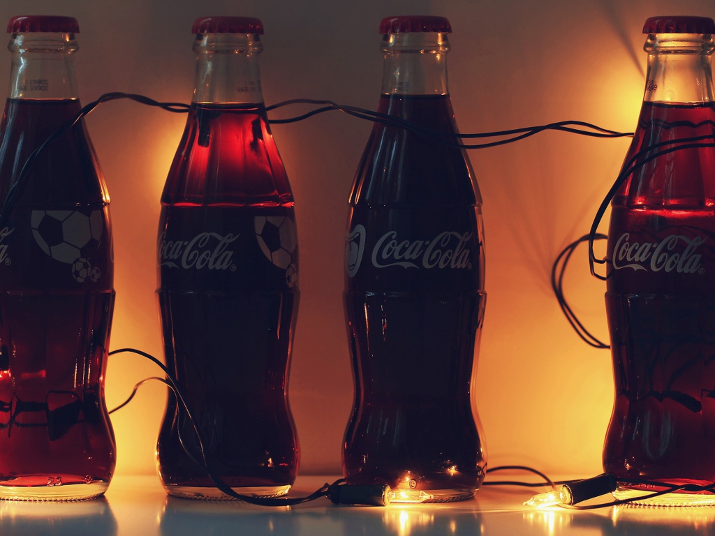 Бутылки Кока-Колы связанные новогодней гирляндой