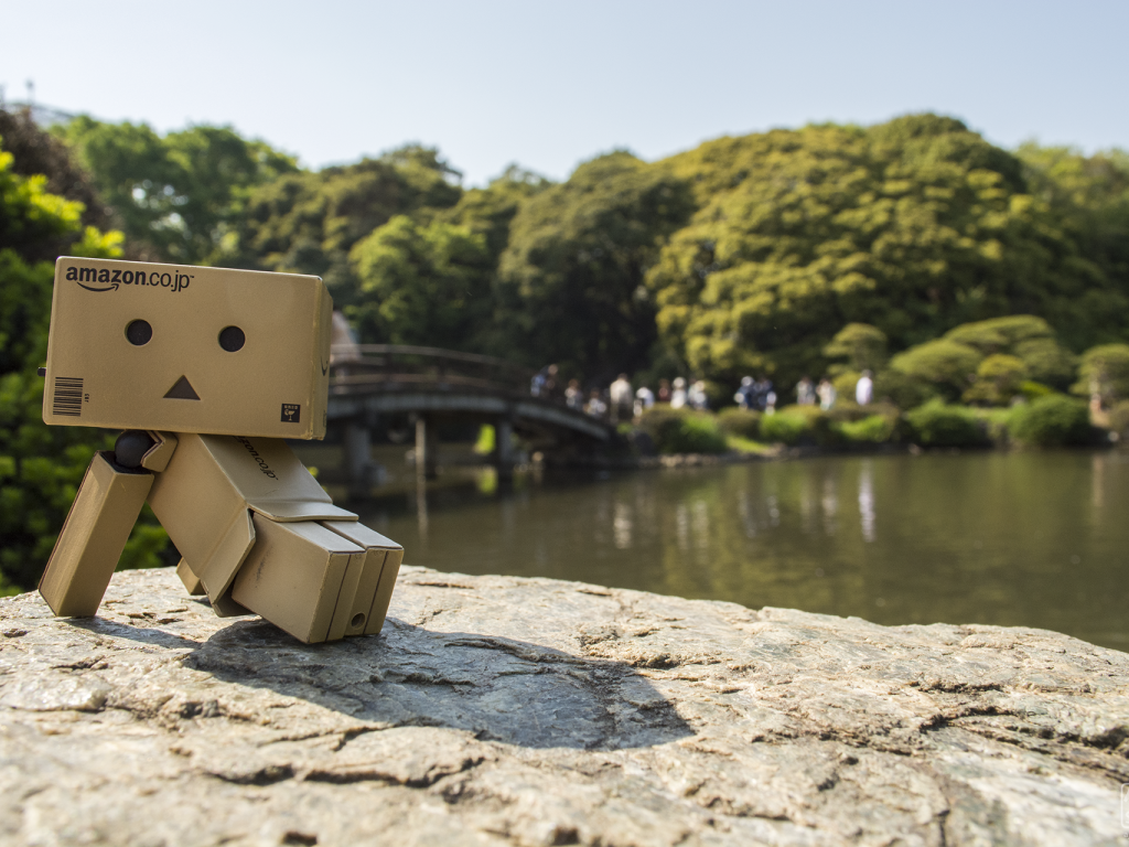 Картонный человечек на камне в саду