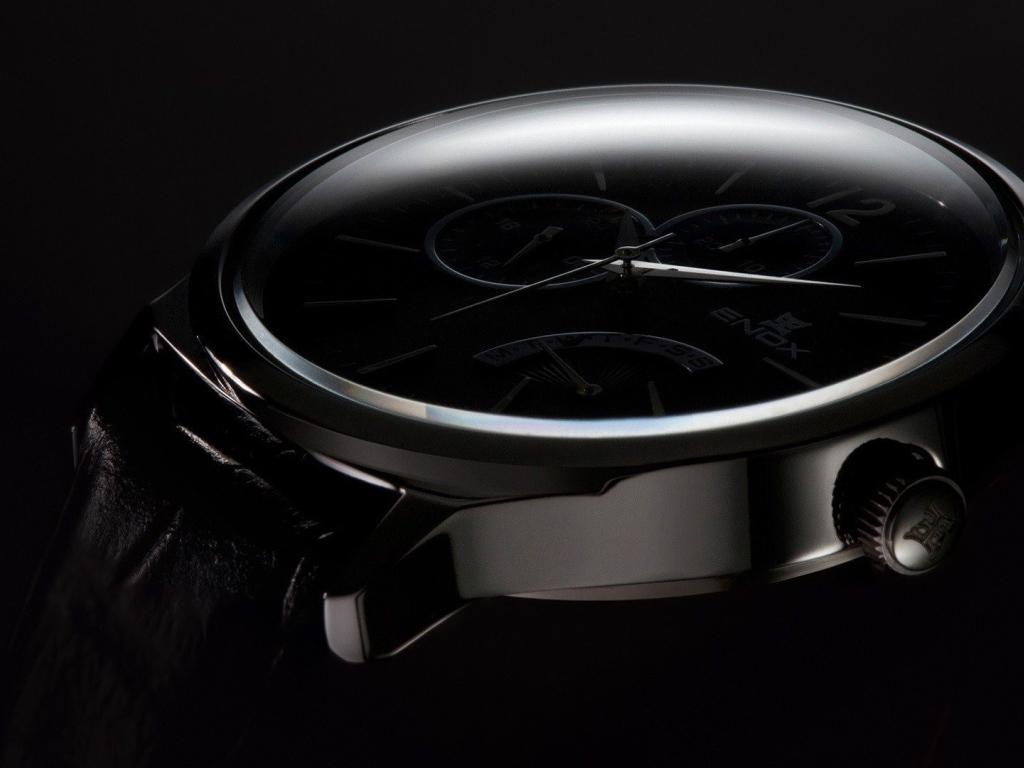 Дорогие черные часы на черном фоне