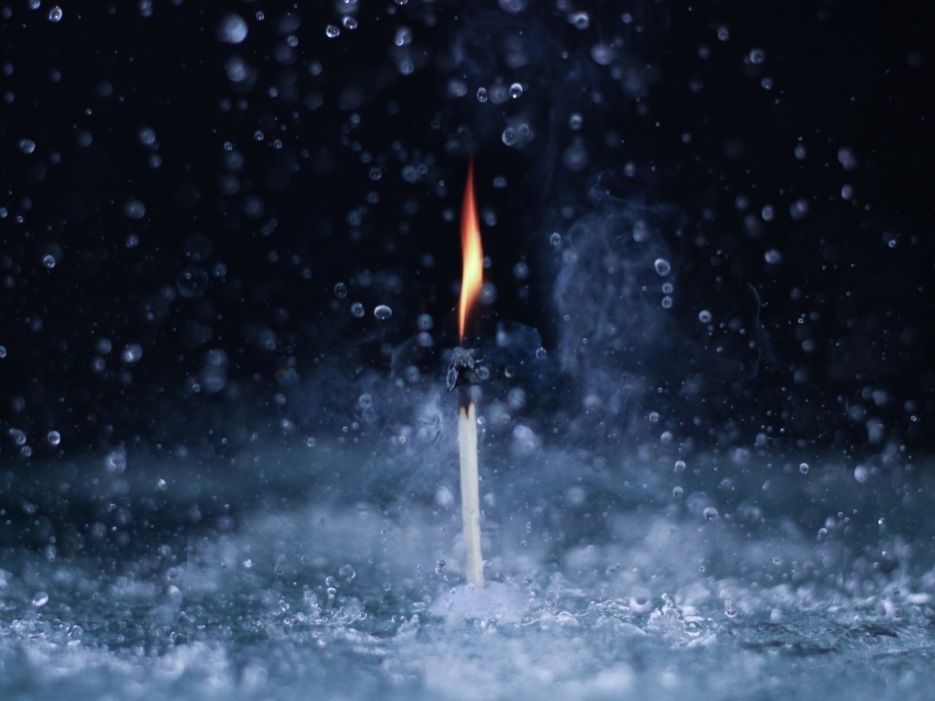 Пламя спички среди капель воды