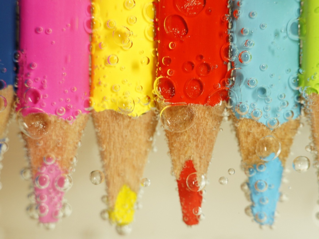 Карандаши в воде среди пузырей воздуха