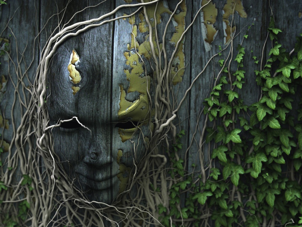 Лицо на деревянном заборе, увитое плющом