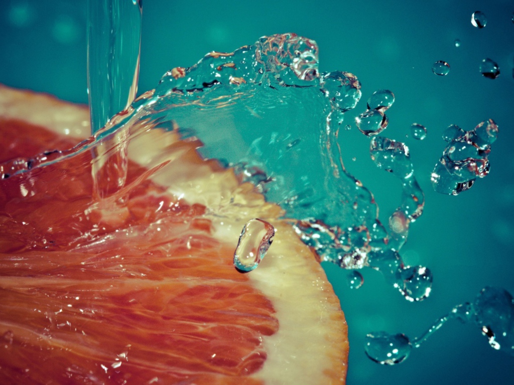 Вода льется на срез грейпфрута